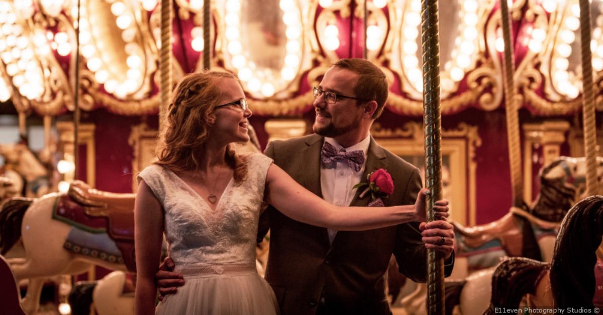 couple smiling at each other on a carousel