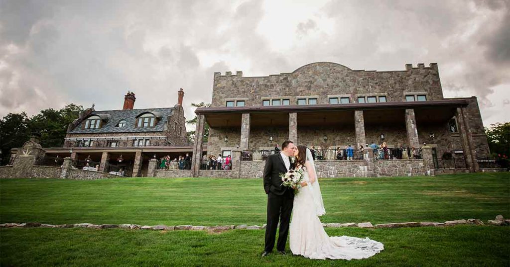 A couple poses in front of the Inn at Erlowest