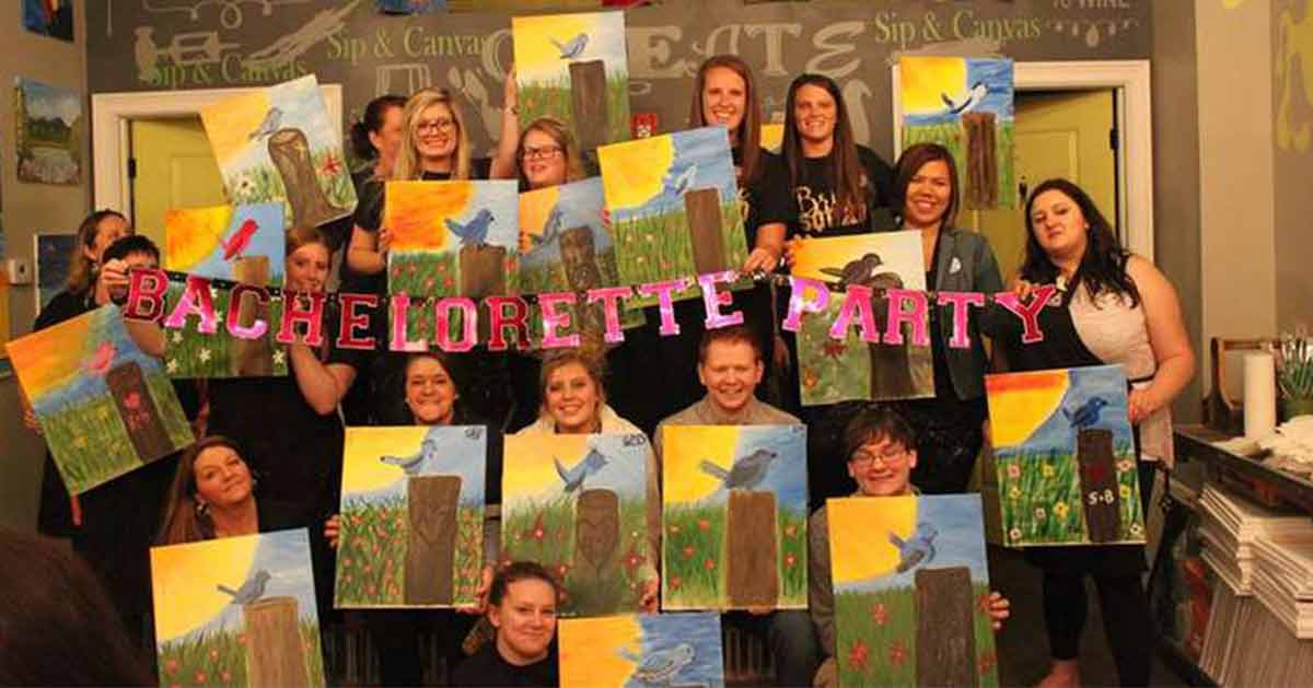 Guests at a bachelorette party pose with their paintings.