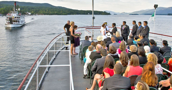 a wedding on a boat with mountains in the background