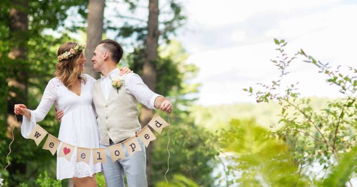 a bride and groom kissing with a sign that says we eloped