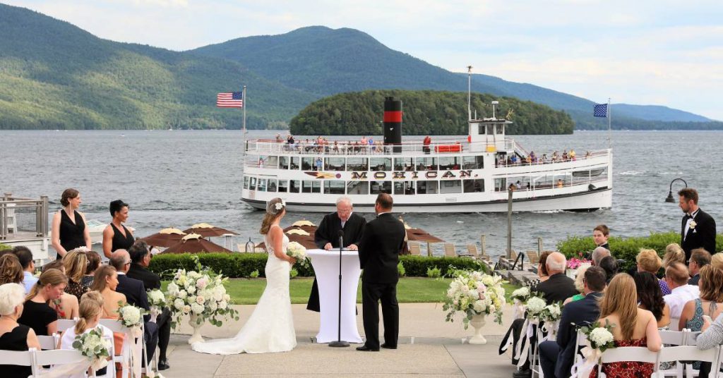 wedding ceremony by lake with steamboat in background
